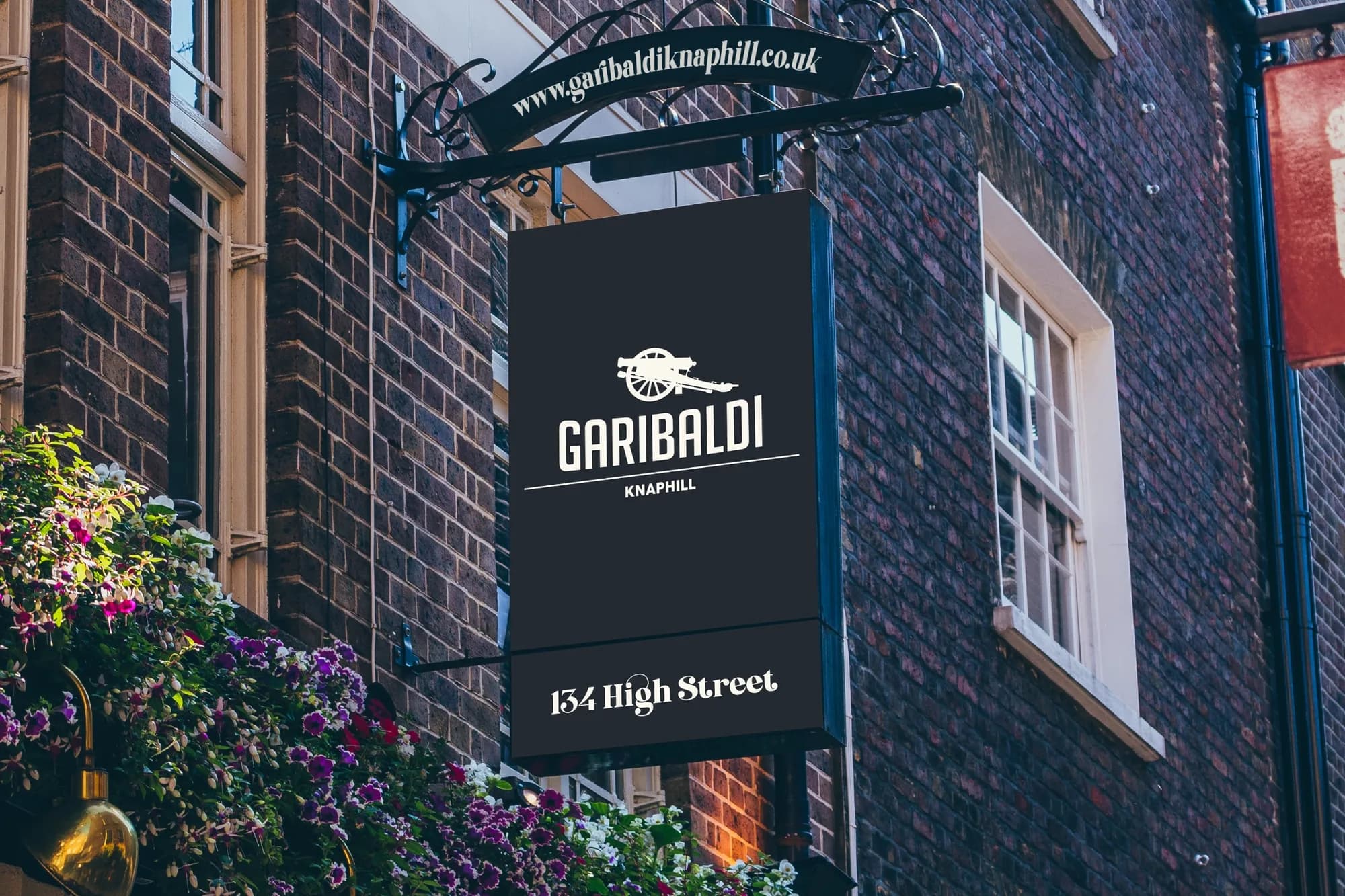 A hanging pub sign on a brick wall: the cannon, GARIBALDI, Knaphill, 134 High Street