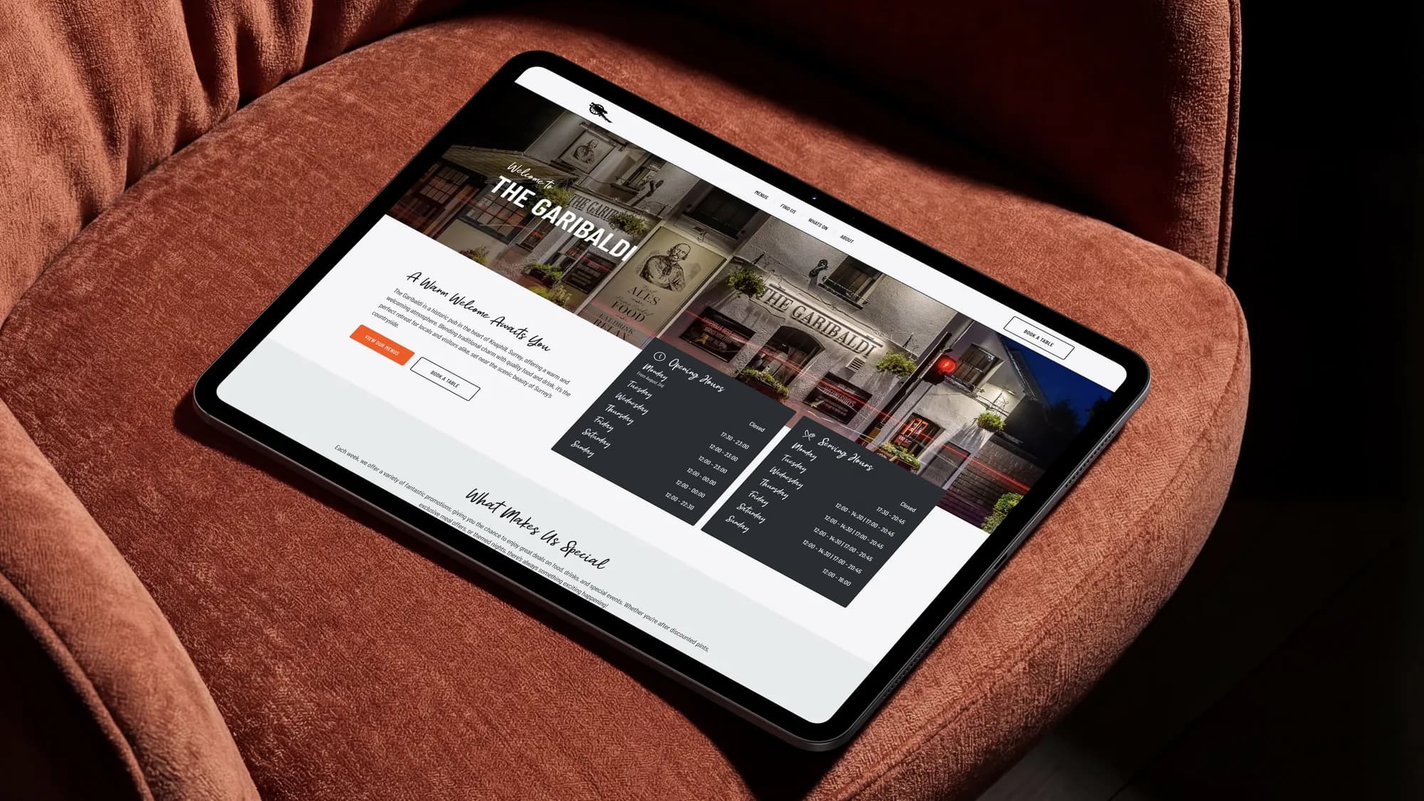 The Garibaldi homepage on an iPad, resting on a rust velvet armchair