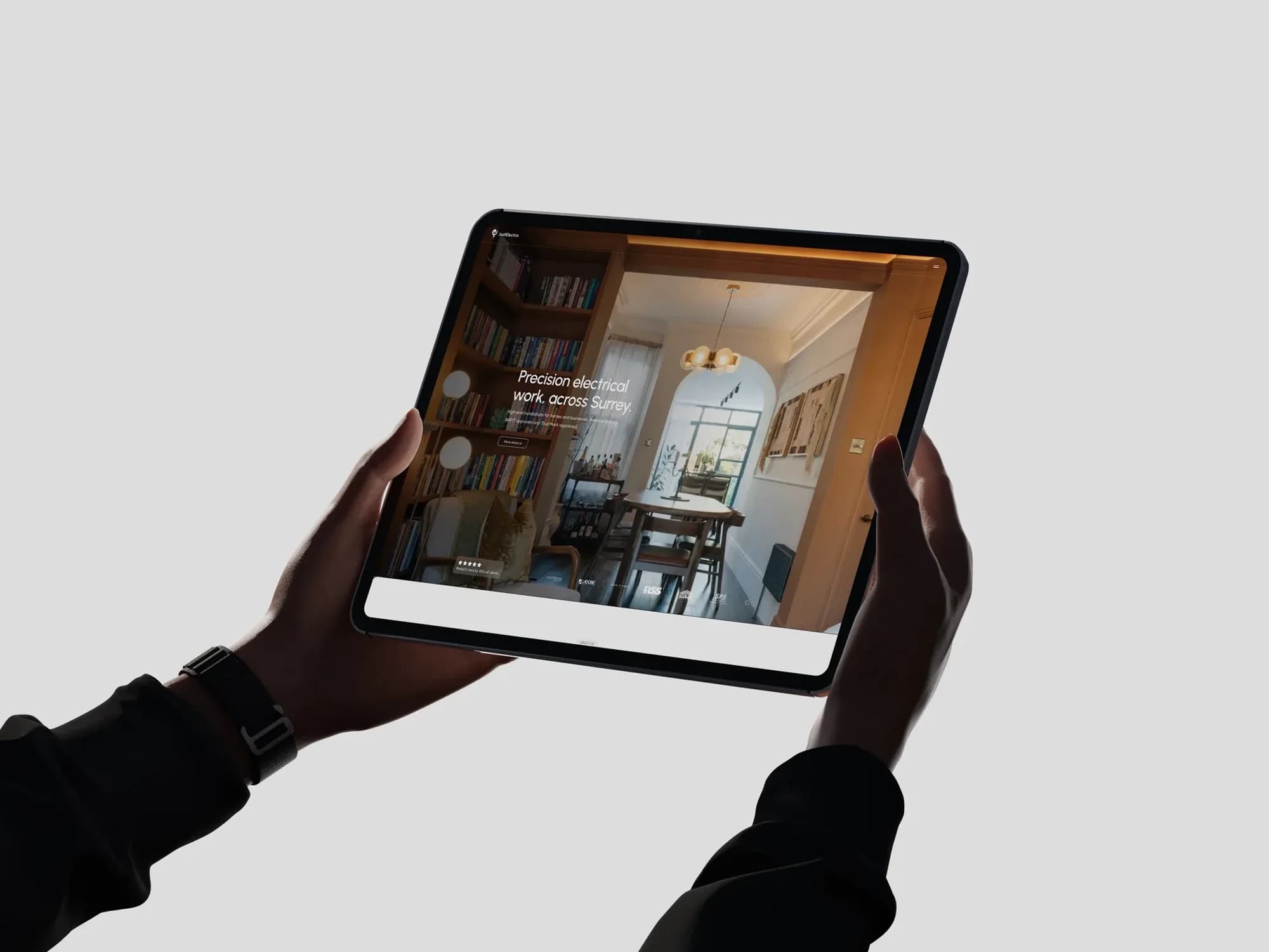 The JustElectrix homepage on an iPad: Precision electrical work, across Surrey