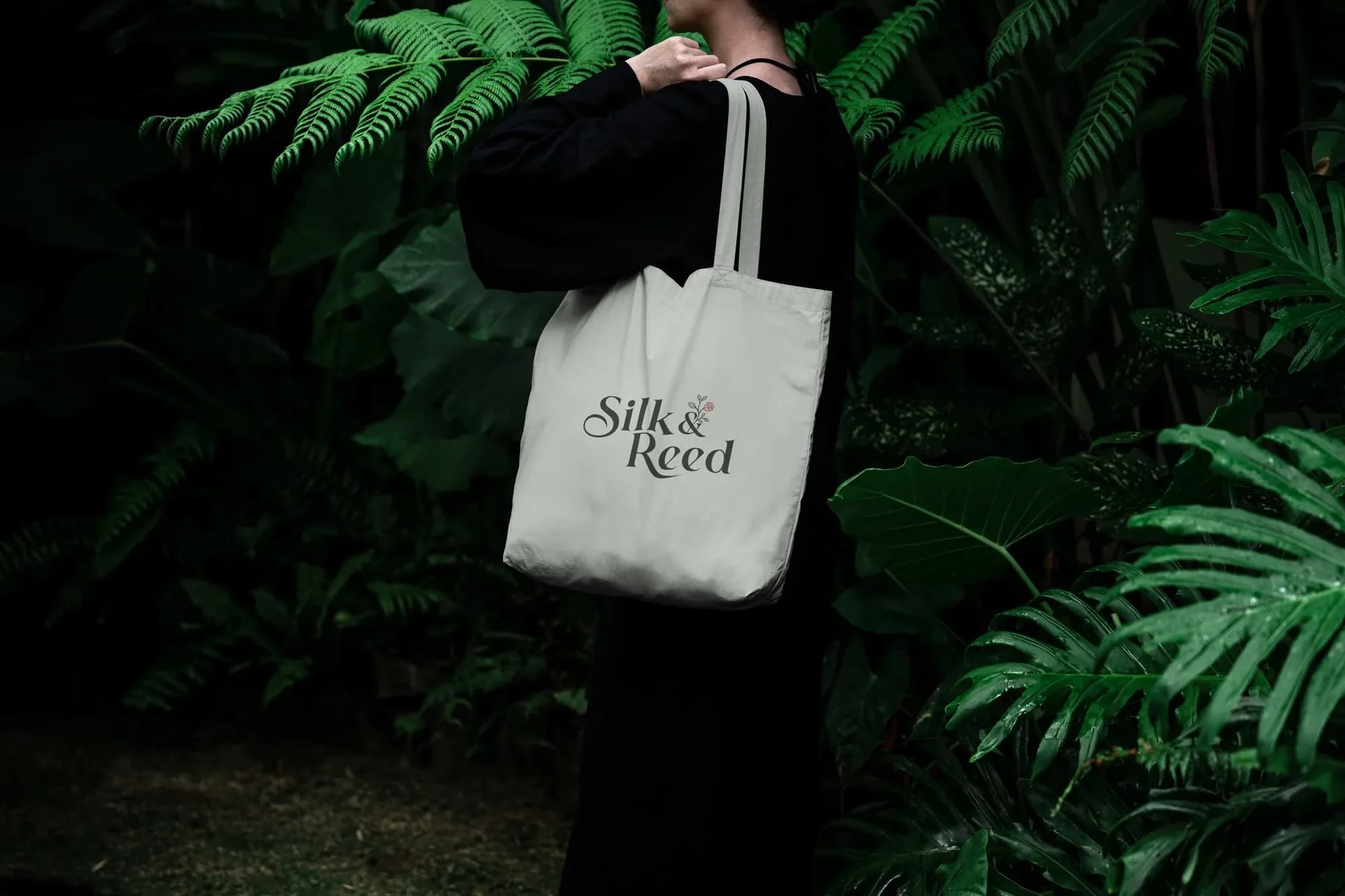 A sage Silk & Reed tote bag carried over the shoulder among ferns