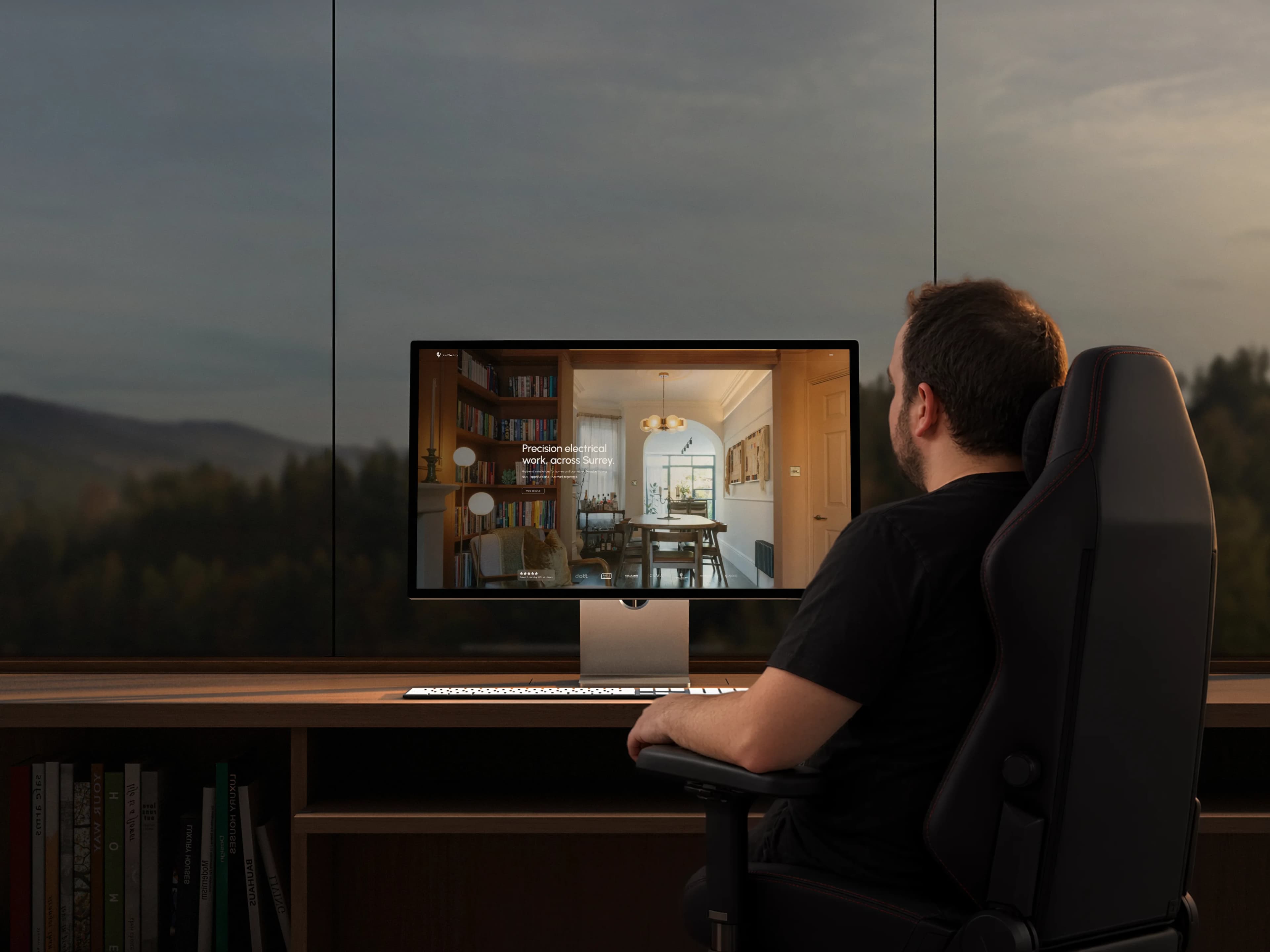 Michael at his desk at dusk, a client website on the monitor